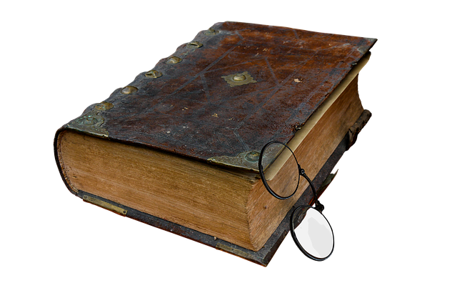 capa-de-livro-antigo-preto-sob-fundo-branco-com-oculos-apoiado-na-capa