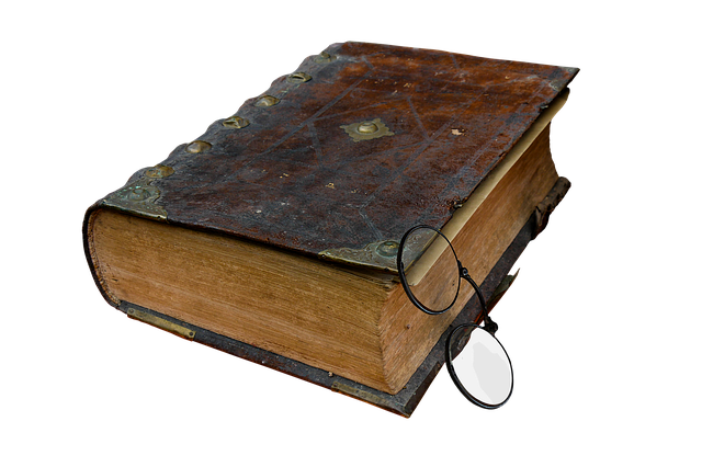 capa-de-livro-antigo-preto-sob-fundo-branco-com-oculos-apoiado-na-capa