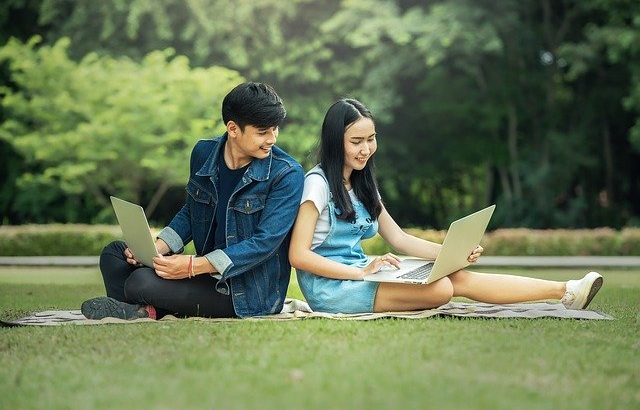 jovens-adultos-sentados-rindo-com-computador