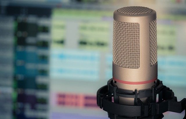 microfone de gravação em frente a tela desfocada de computador